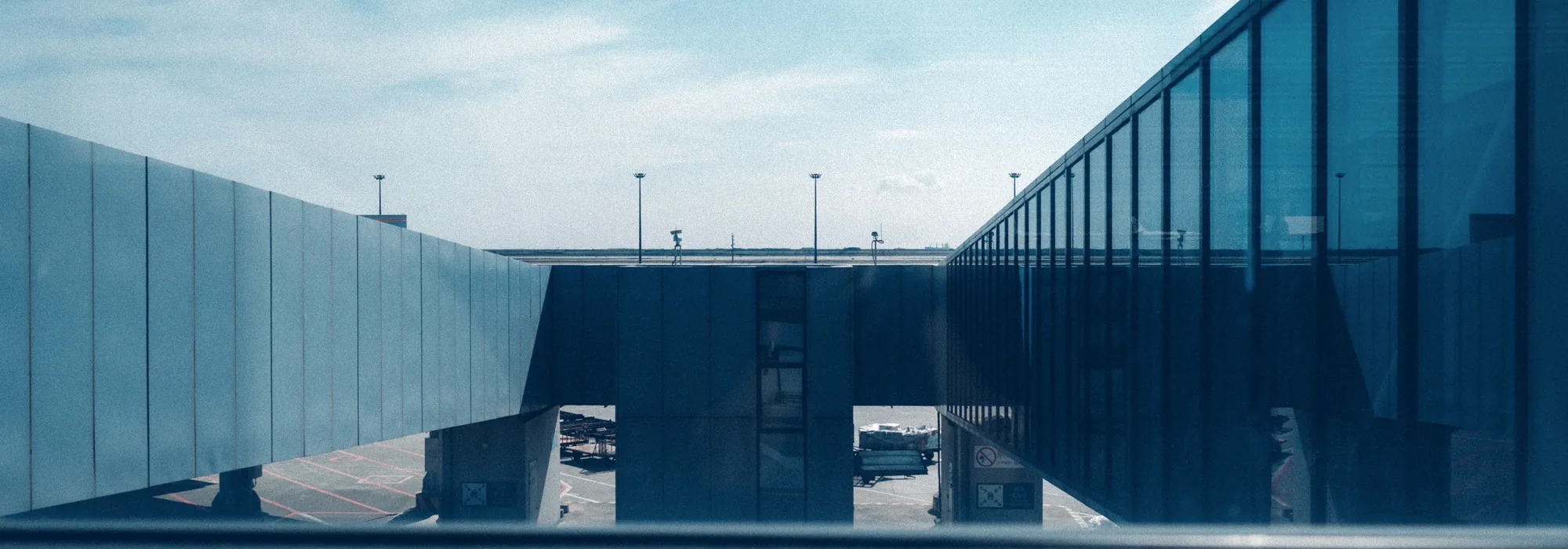 Passerelle vitrée d'un aéroport sous un ciel bleu